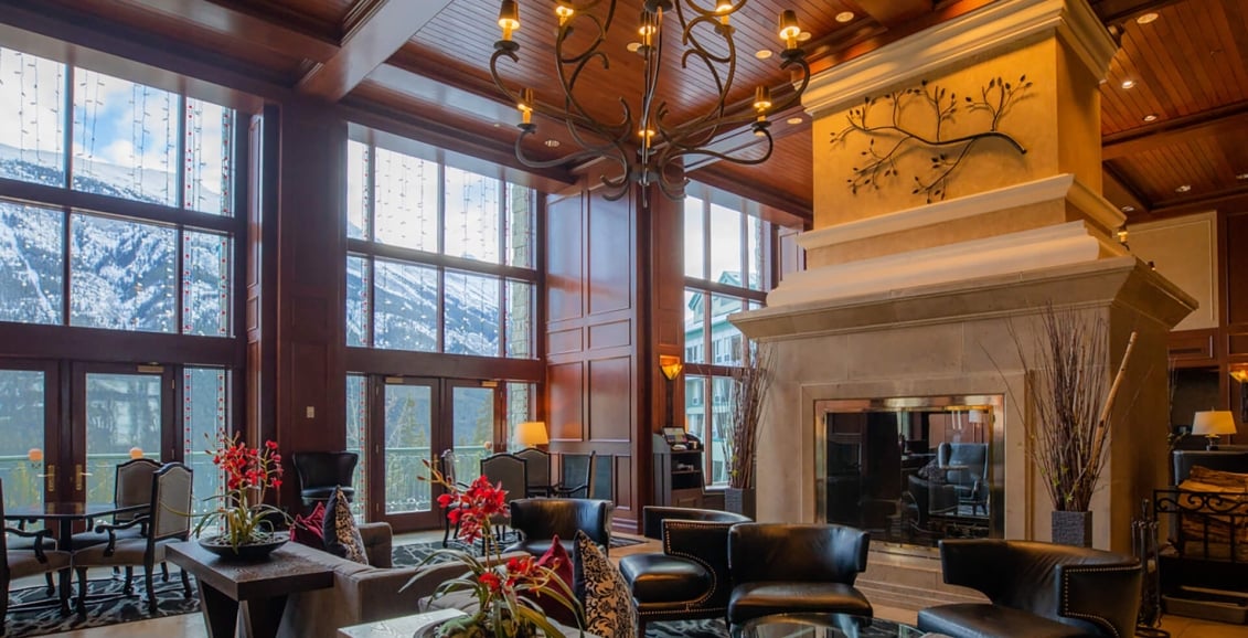 A lobby area with a big chandelier and floor length windows