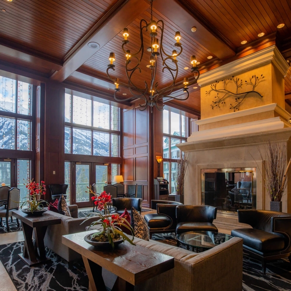 A lobby area with a big chandelier and floor length windows