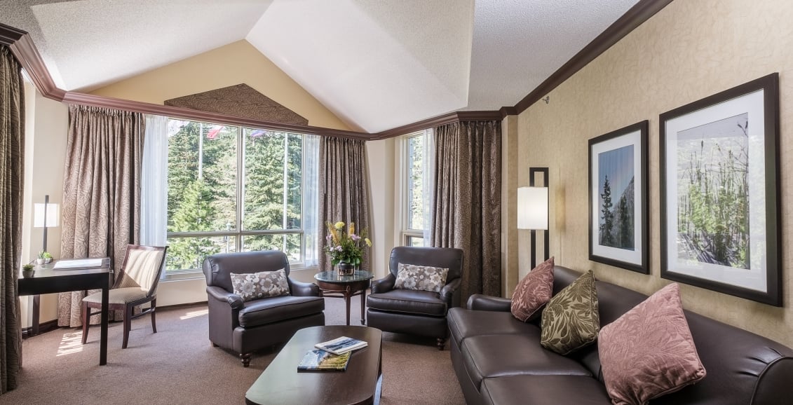 Living area with couch, chairs and a view of trees