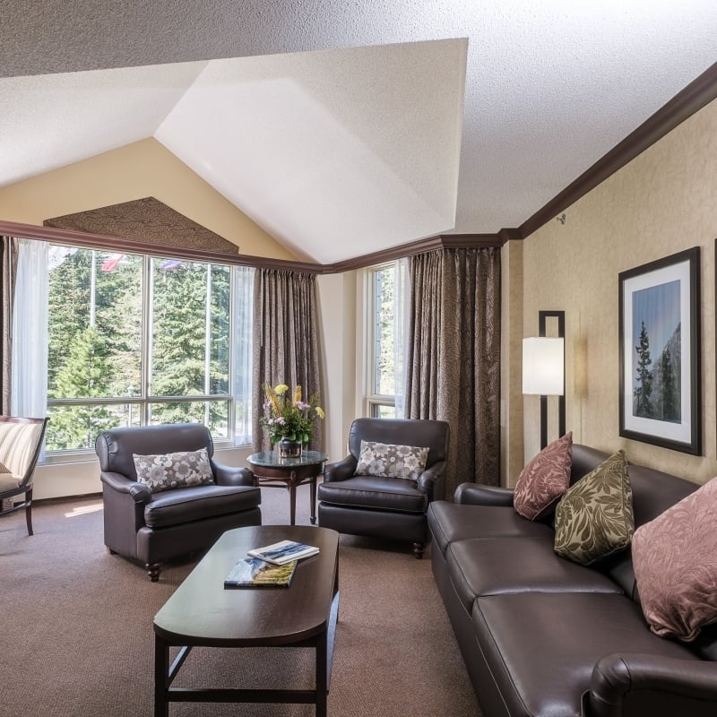 Living area with couch, chairs and a view of trees