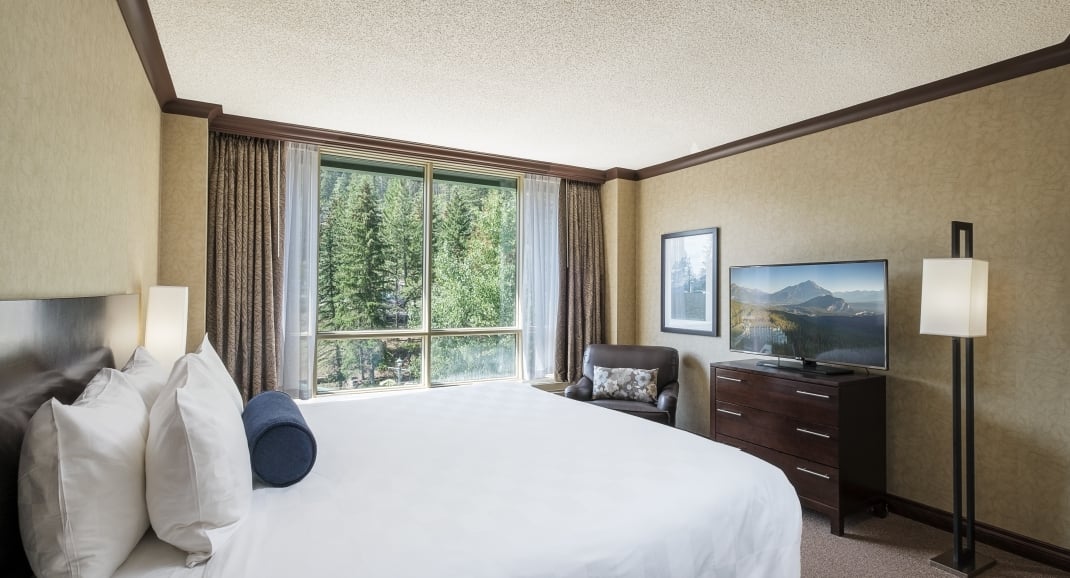 Bedroom of the Junior Suite with views of trees