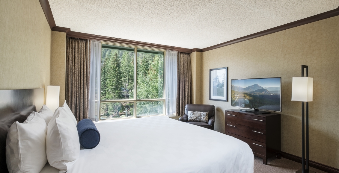 Bedroom of the Junior Suite with views of trees