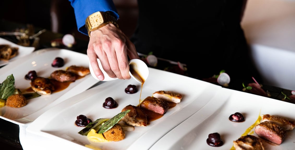 A host pouring liquid on food