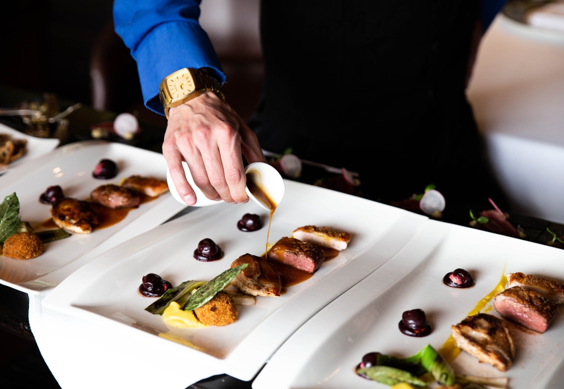 A host pouring liquid on food