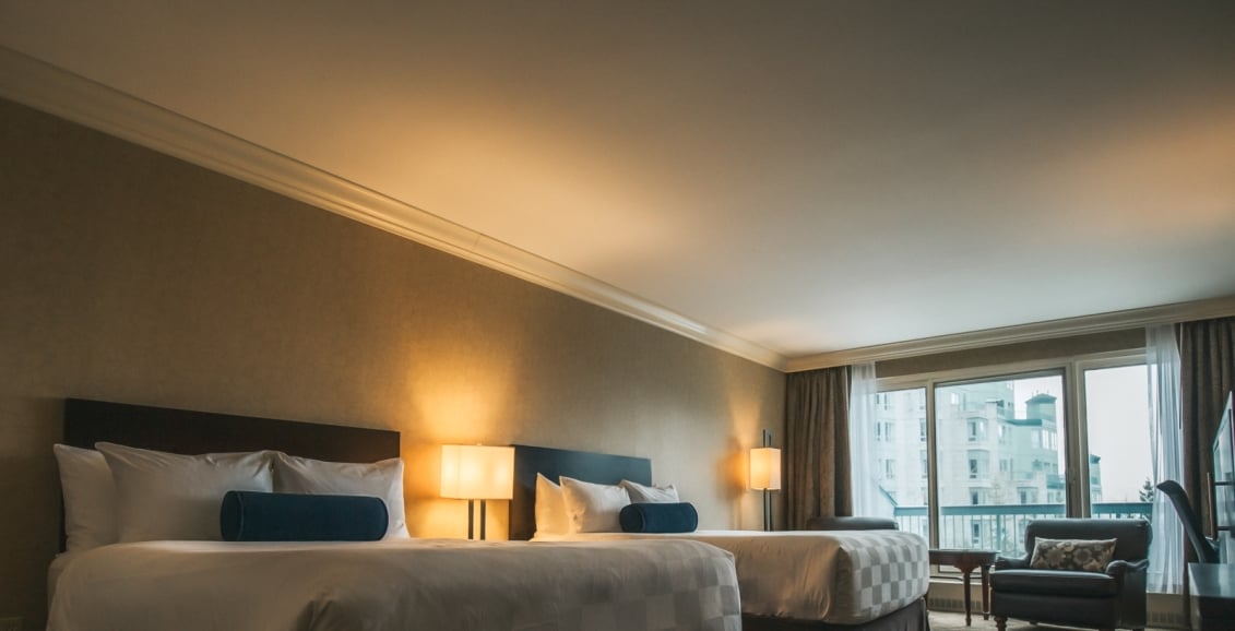 Two beds in a hotel room with a balcony