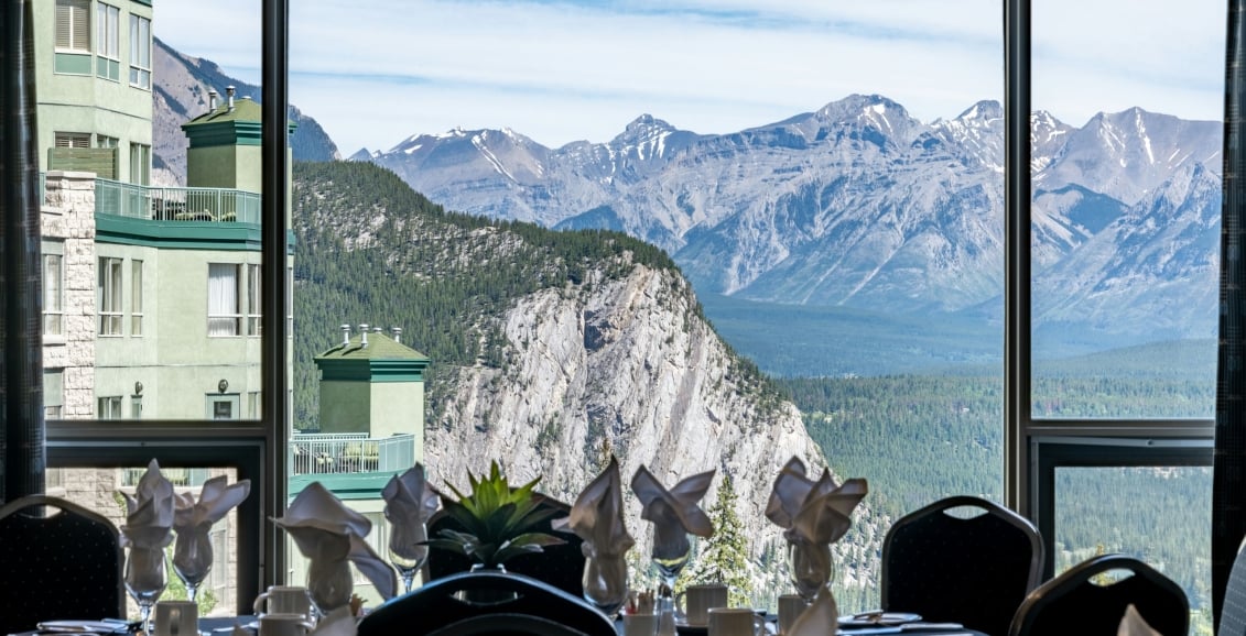 Chairs and tables set for dining with a view of the mountains