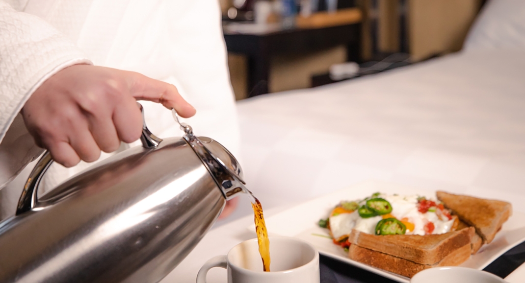 A person pouring coffee into a teacup