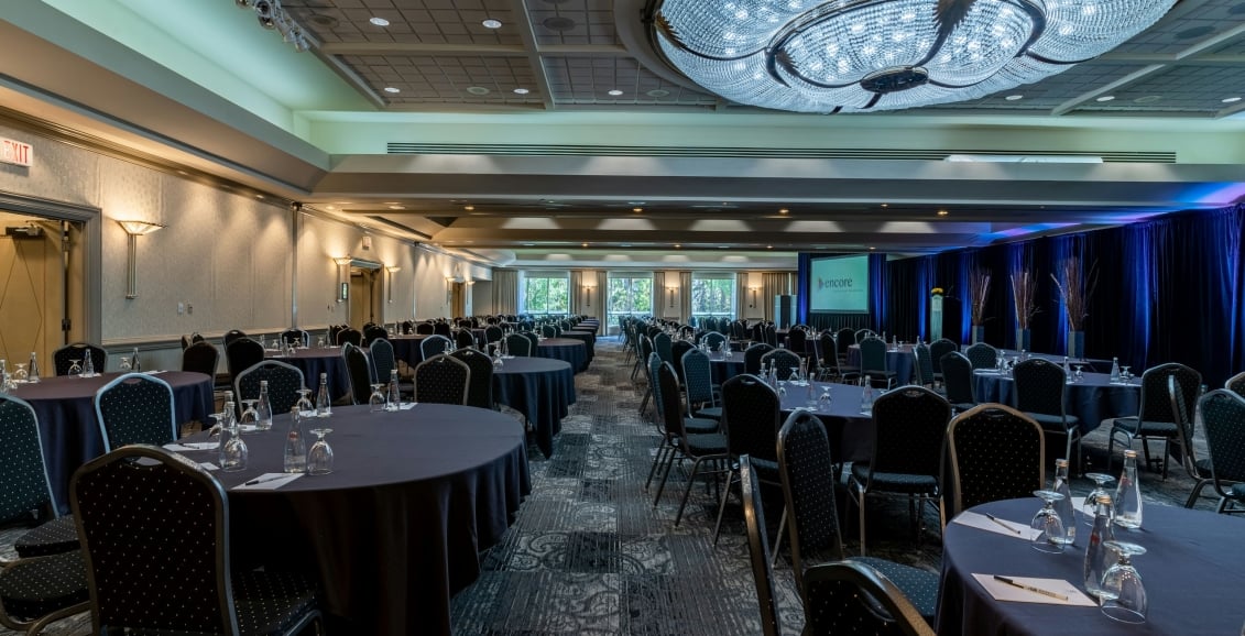 A ballroom with round tables and chairs