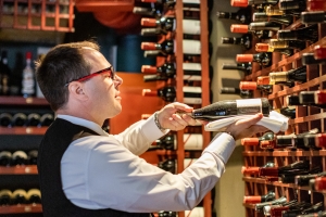 Man in a wine cellar pulling wine