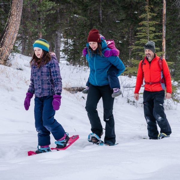 Family snowshoeing in the forest