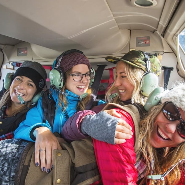 Four women in hats laughing and smiling