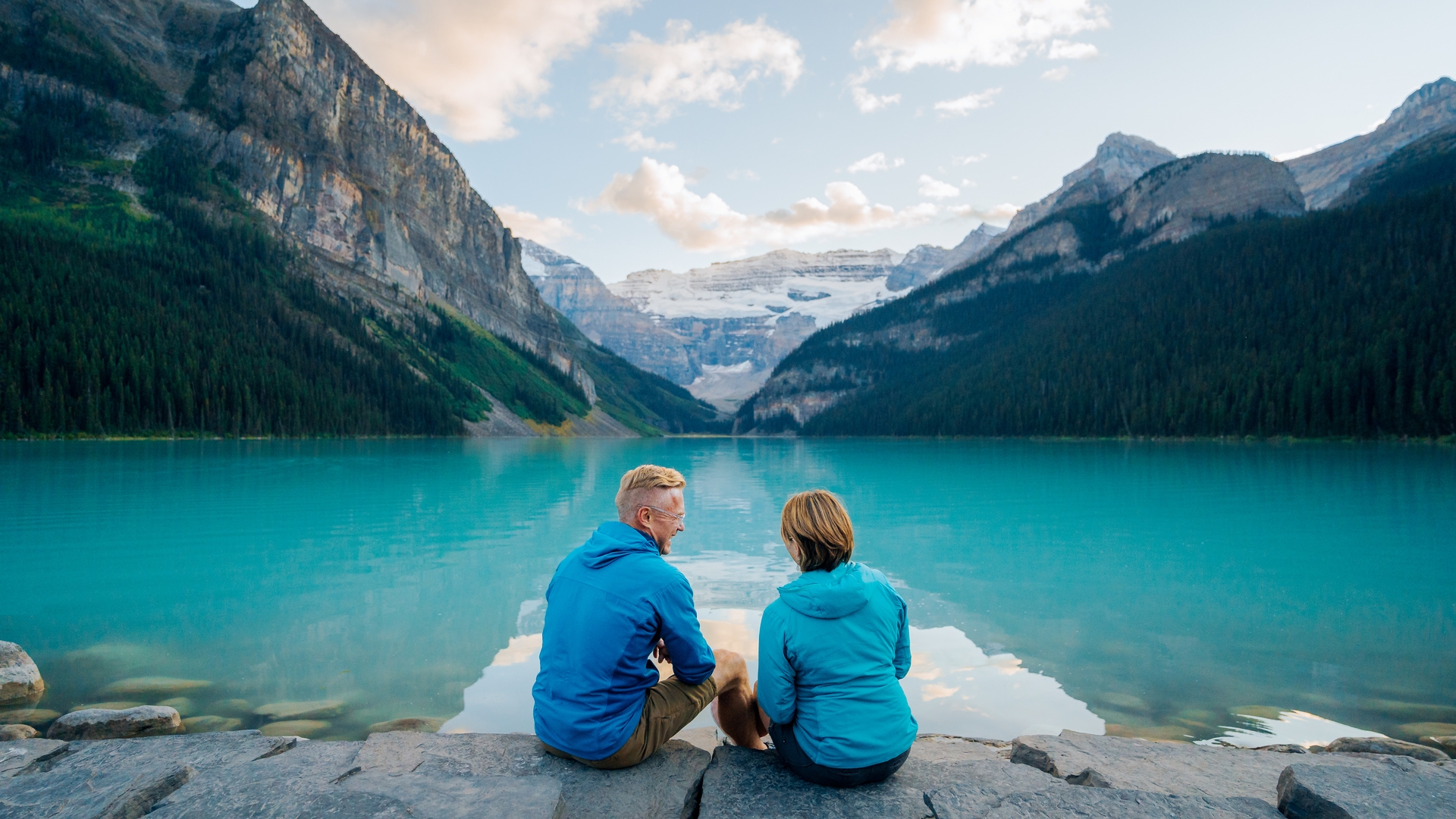 Two people sitting on the edge of the water