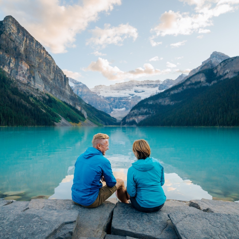 Two people sitting on the edge of the water