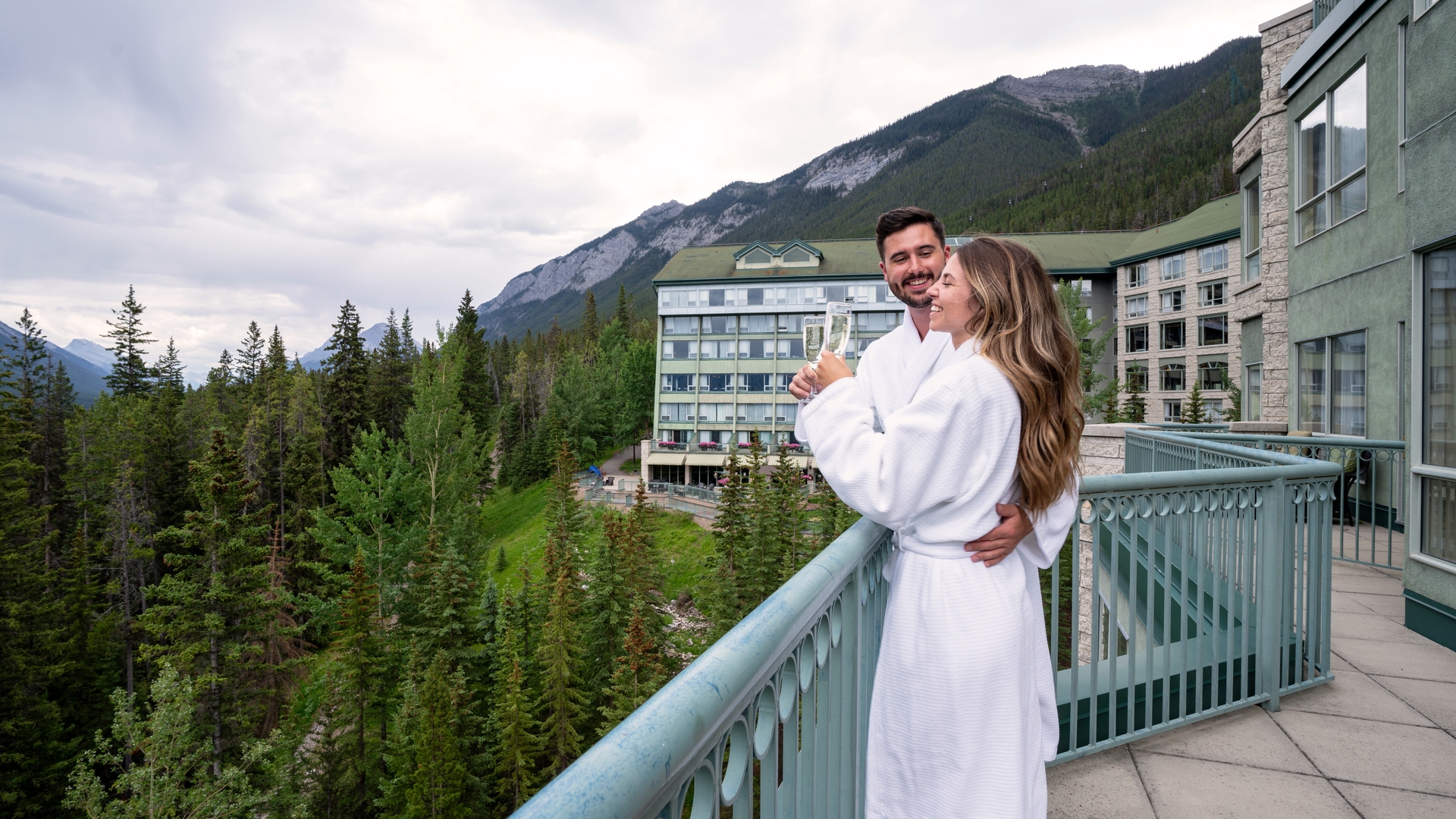 Two people standing on a balcony smiling