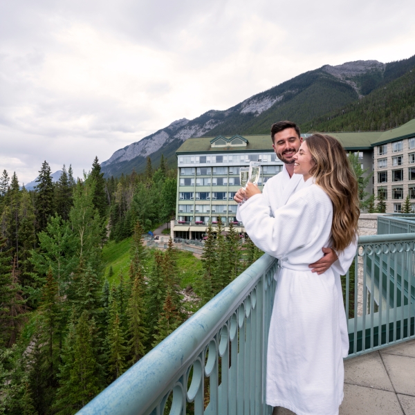 Two people standing on a balcony smiling