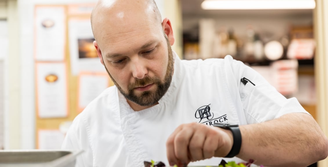 A chef setting food on a table