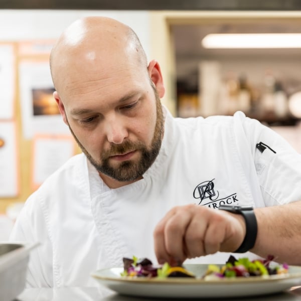 A chef setting food on a table