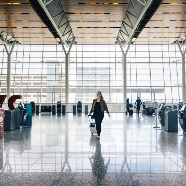 A woman walking in the airport with her hand luggage