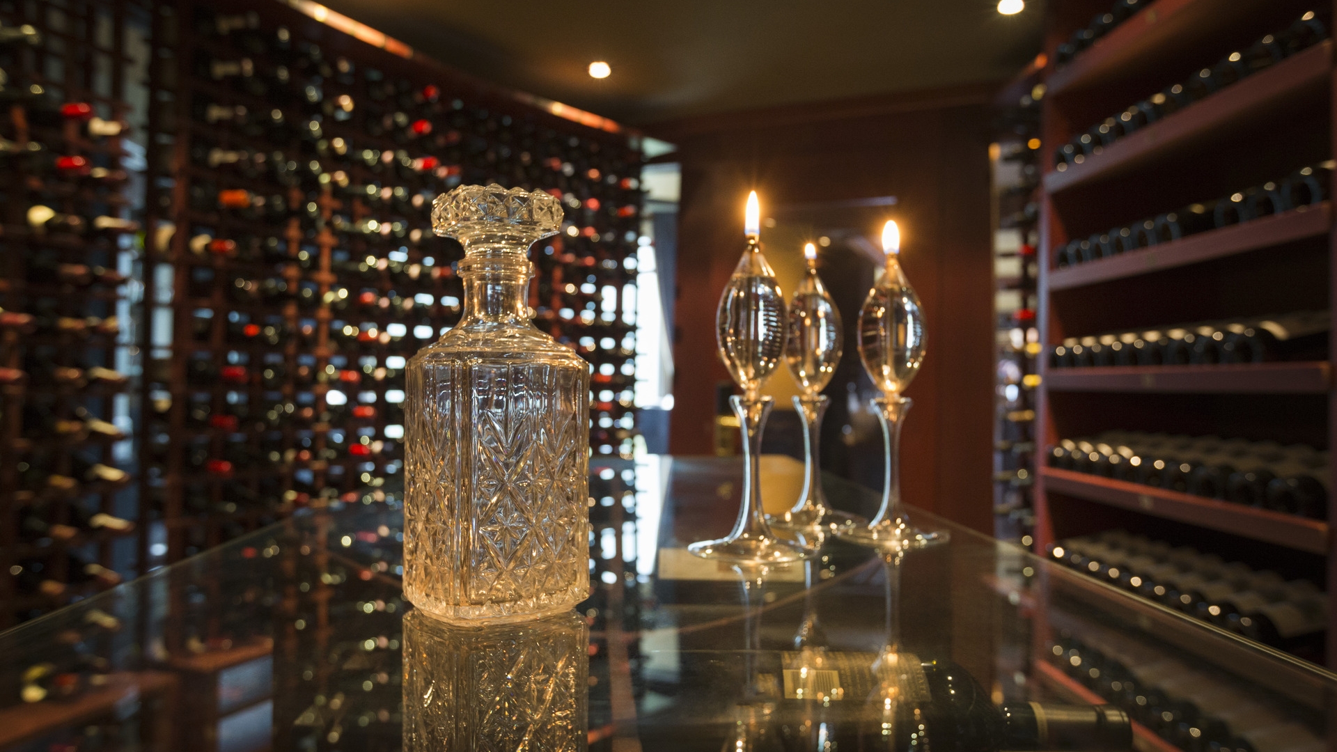 A decanter in the foreground and wines in shelves at the background