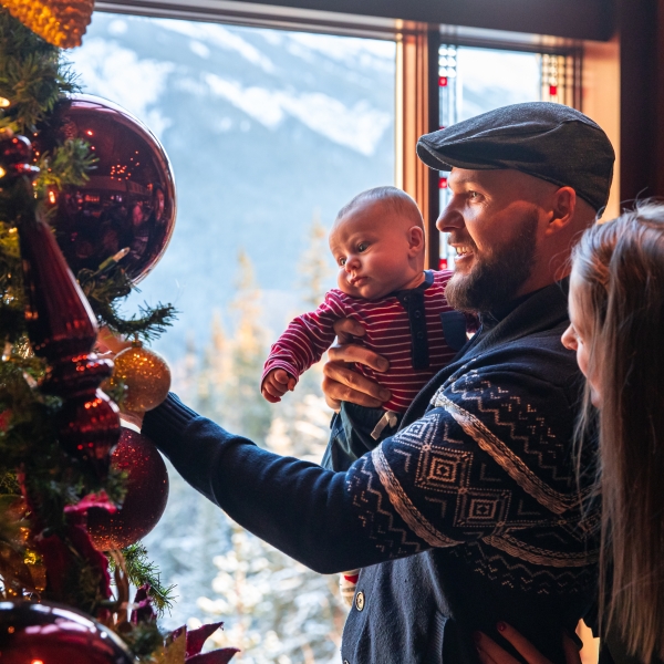 man and woman with child at christmas tree
