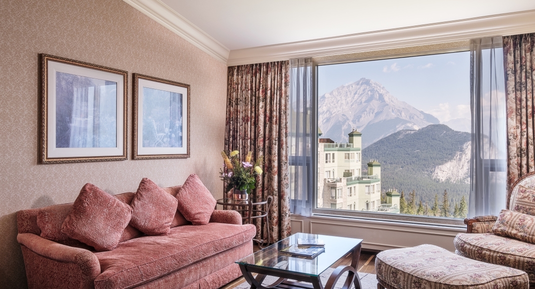 beautiful living room with view of hotel and mountains