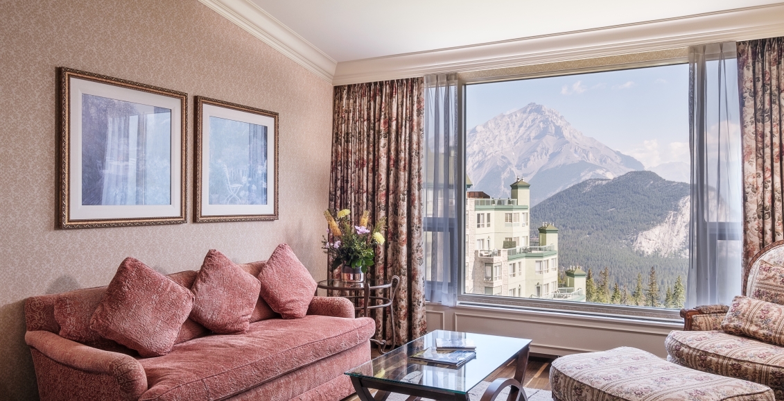 beautiful living room with view of hotel and mountains