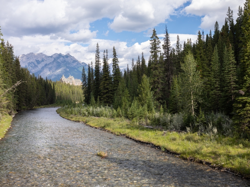 Clear waters of the Spray River and Fairmont Banff Springs Hotel with Sulphur Mountain in the distance, Alberta, Canada