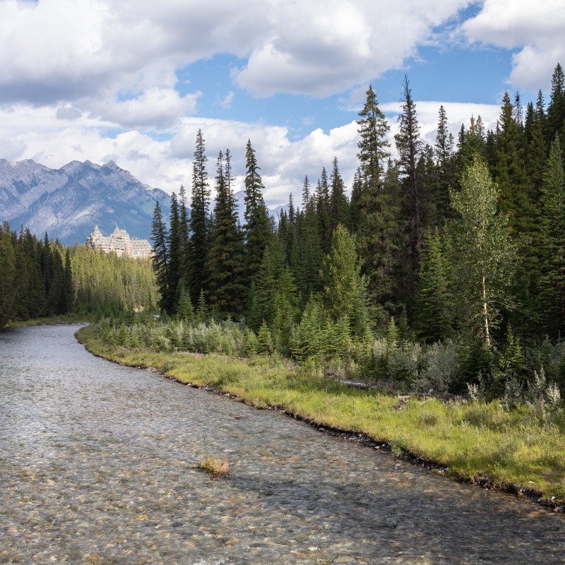 Clear waters of the Spray River and Fairmont Banff Springs Hotel with Sulphur Mountain in the distance, Alberta, Canada