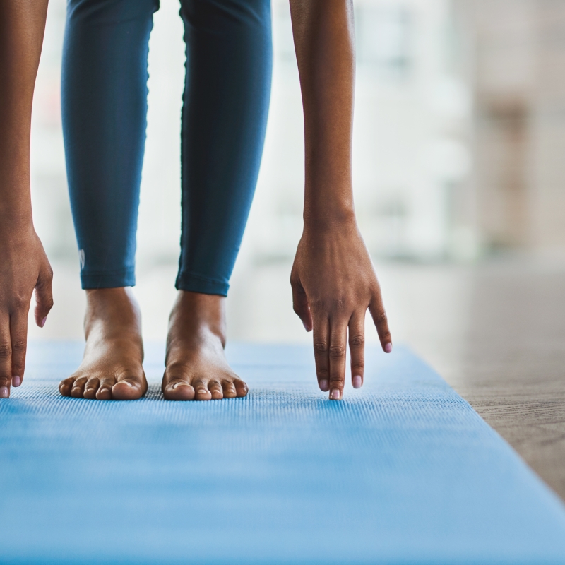 Shot of an unrecognisable woman practicing a yoga routine at home