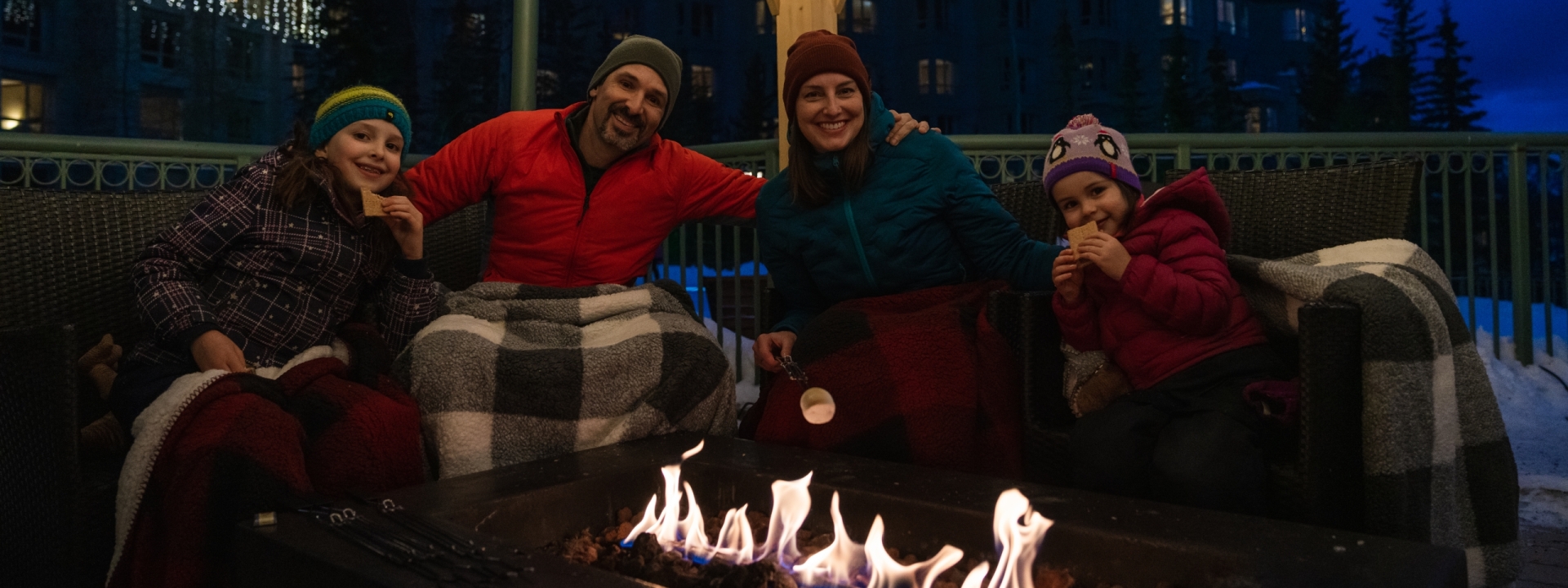 Family posing for camera with firepit