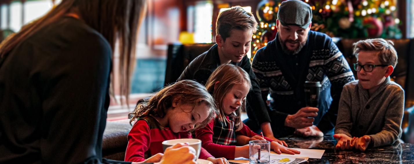 A family sits around a table at Christmas time at the Larkspur at the Rimrock
