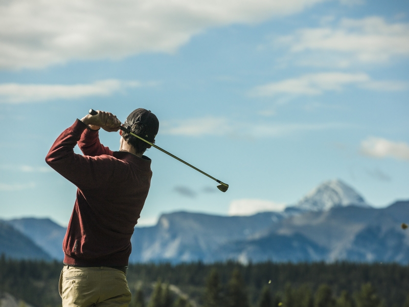 Golfer swinging for the mountains in Banff National Park