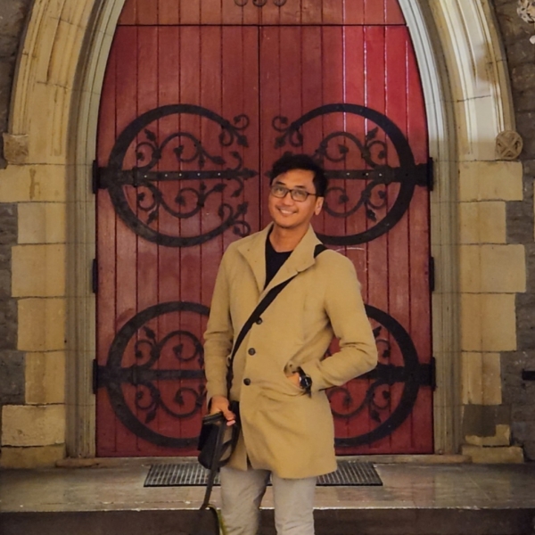 man in front of red door
