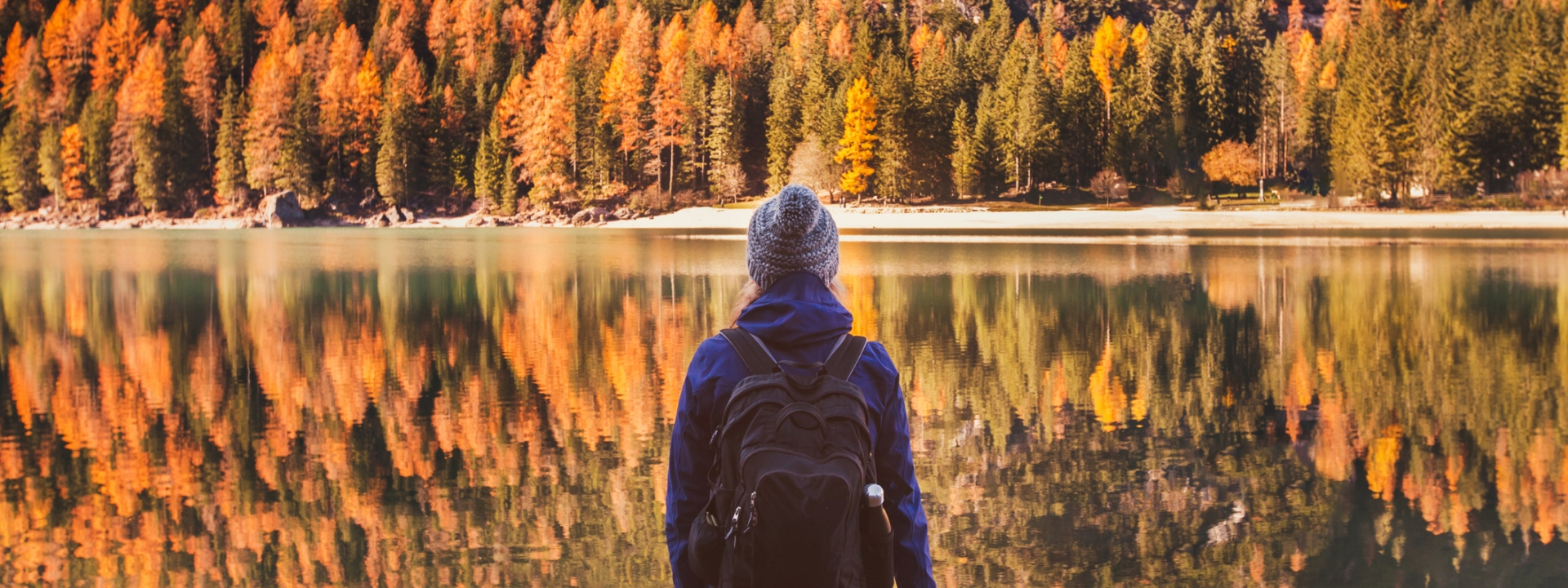 woman looking at a lake in the fall