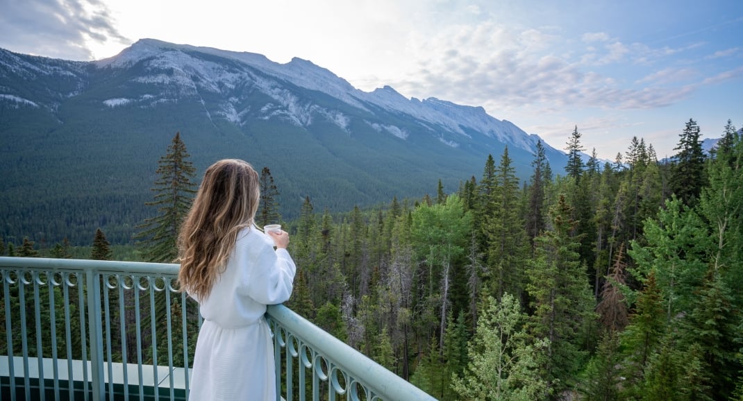 Woman drinking coffee looking at the mountain Rimrock Banff
