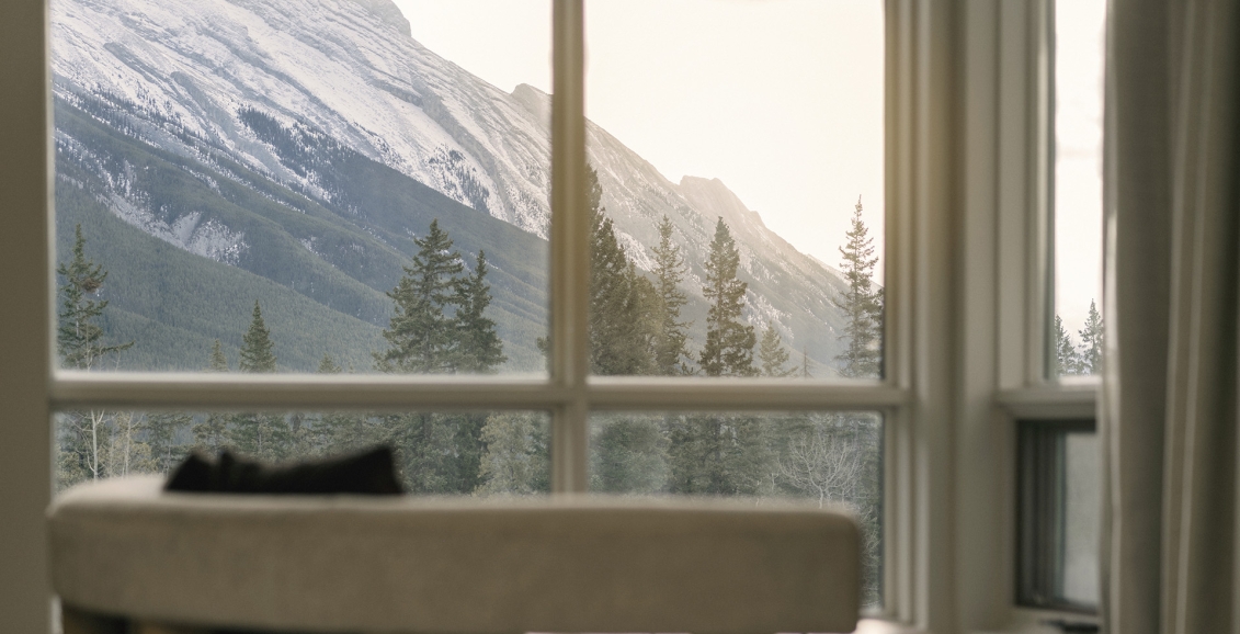 View of the mountains outside the room of a suite at Rimrock Banff