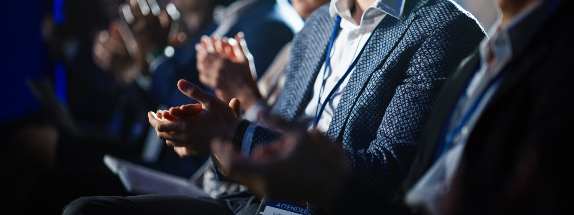 Business people at a conference in Radiance Ballroom clapping hands