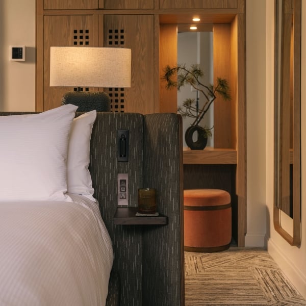 A bed with a vanity in the background in a Valley View Suite at Rimrock Banff, Emblems Collection