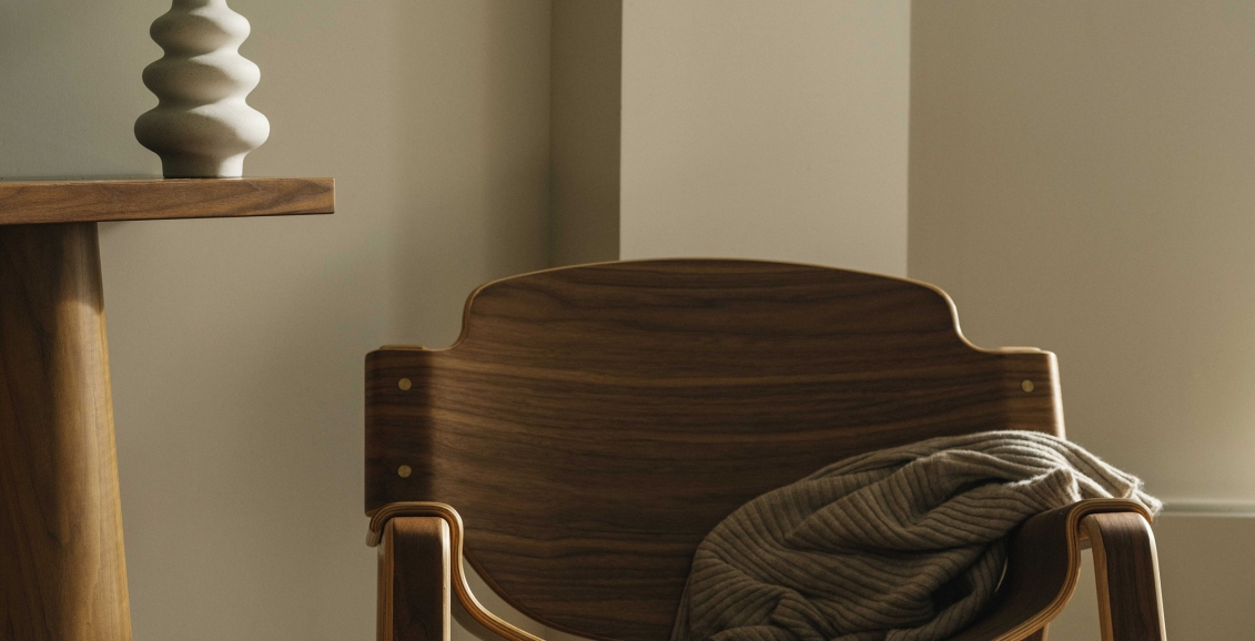 A wooden chair and vase add to the bright clean decor of a Valley View Suite at Rimrock Banff, Emblems Collection