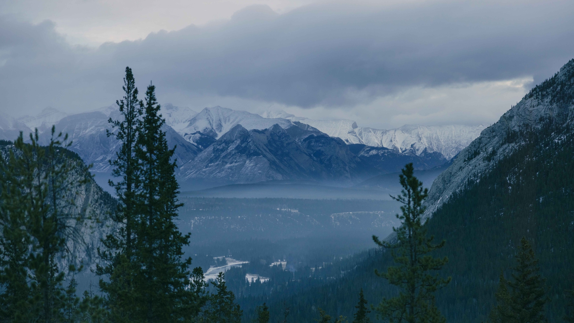 The View from a window at Rimrock Banff, with the Bow Valley below and tall mountains in the distance.