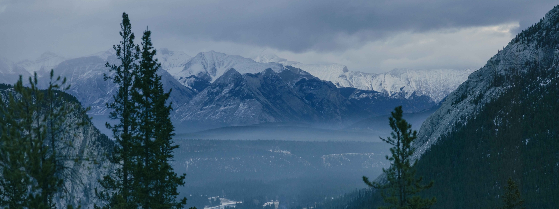 The View from a window at Rimrock Banff, with the Bow Valley below and tall mountains in the distance.