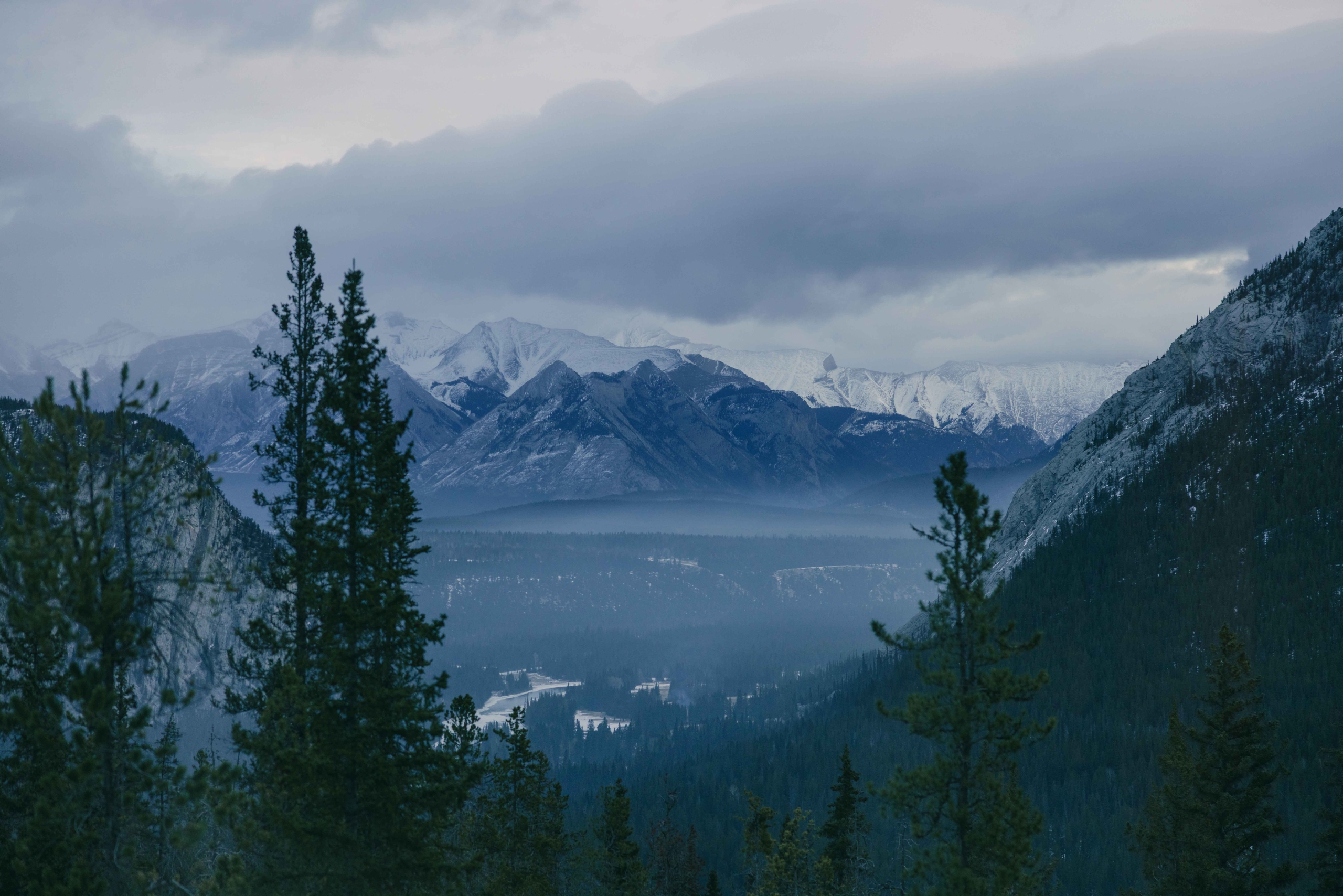 The View from a window at Rimrock Banff, with the Bow Valley below and tall mountains in the distance.