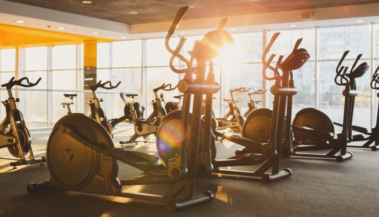 A gym with cardio equipment against the window