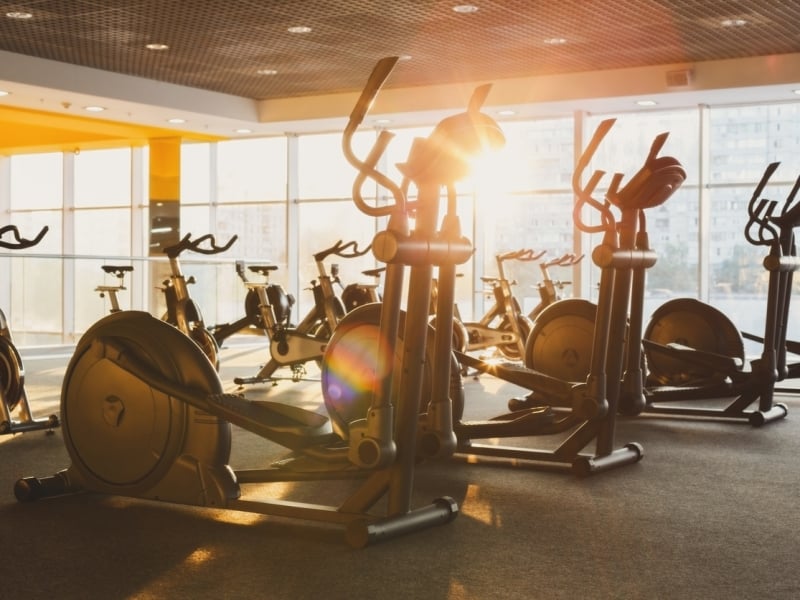 A gym with cardio equipment against the window