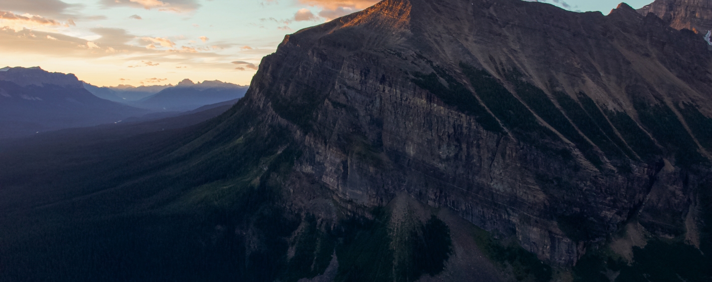 Sunrise light touching the mountain above the turquoise waters of Lake Louise, viewed from the Little Beehive trail.