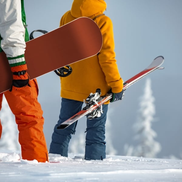 A skier and a snowboarder enjoying the hill before apres at Rimrock Banff.