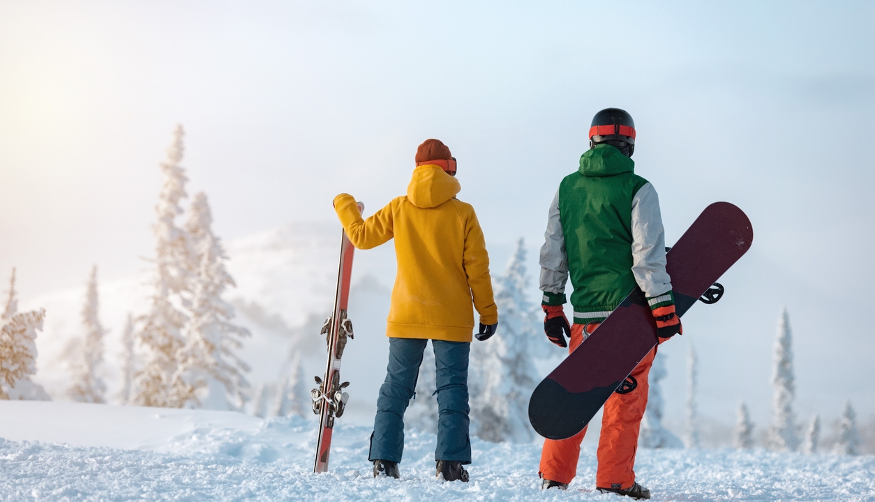 A skier and a snowboarder enjoying the hill before apres at Rimrock Banff.